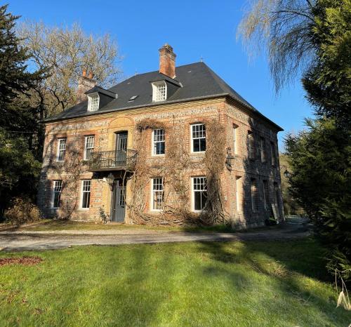 Cette ancienne maison en briques dispose d'un balcon sur une pelouse. dans l'établissement Aux Jolies Sources, à Saint-Aubin-sur-Scie
