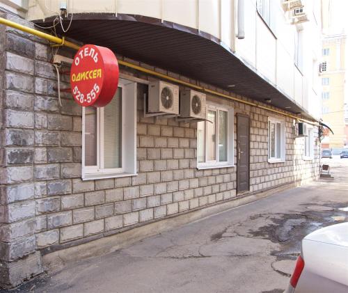 a building with a red sign on the side of it at Hotel Odisseya in Ryazan