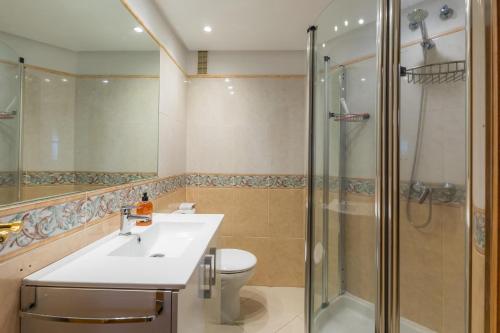 a bathroom with a toilet and a sink and a shower at Frente al mar in Cala Millor