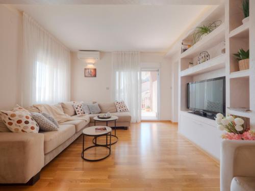 a living room with a couch and a flat screen tv at Hotel Hermes Budva in Budva