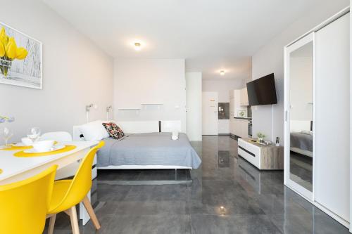 a bedroom with a bed and a table and yellow chairs at Apartament Paraiso by Renters in Łukęcin