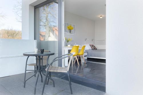 a living room with a table and yellow chairs at Apartament Paraiso by Renters in Łukęcin