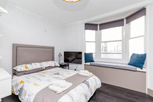a white bedroom with a large bed and a window at CITY HEART BRIGHTON in Brighton & Hove