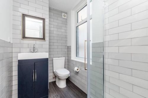 a bathroom with a toilet and a sink and a window at CITY HEART BRIGHTON in Brighton & Hove