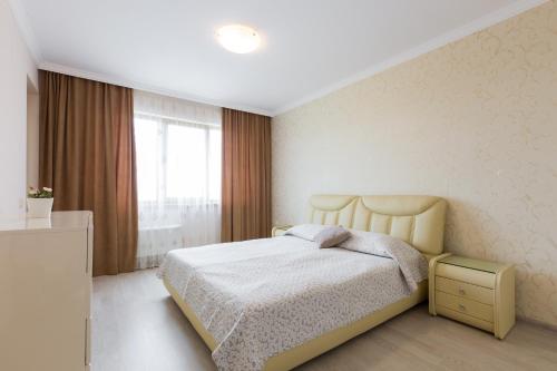 a white bedroom with a bed and a window at FLORENCE SUITES APART HOTEL in Sveti Vlas