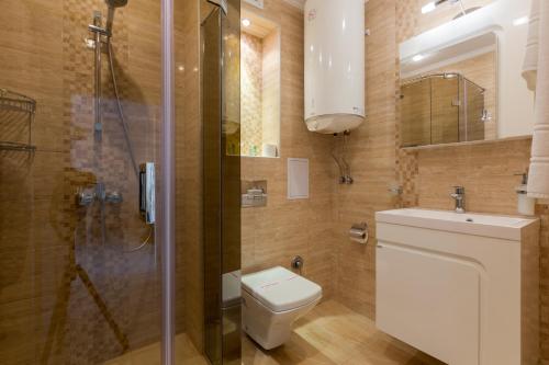 a bathroom with a toilet and a shower and a sink at FLORENCE SUITES APART HOTEL in Sveti Vlas
