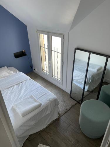 - une chambre avec un miroir, un lit et une chaise dans l'établissement Beautiful Lincoln Apartment, à Paris