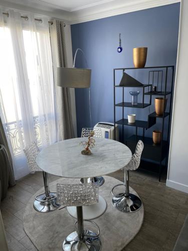une salle à manger avec une table et des chaises blanches dans l'établissement Beautiful Lincoln Apartment, à Paris