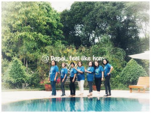 Un groupe de femmes en chemises bleues debout à côté d'une piscine dans l'établissement Papai Country Lodge SHA, à Ban Mae Pong