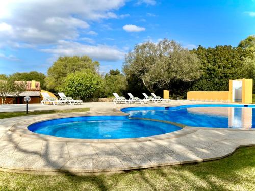 una piscina en un patio con sillas alrededor en Punta D'Acu Country Resort, en Arzachena