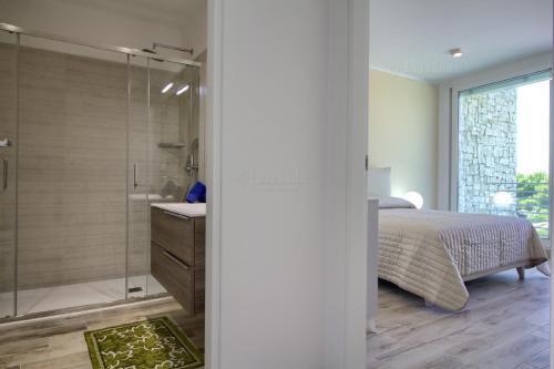 a bedroom with a bed and a glass shower at Jacuzzi Holiday Homes in Leuca