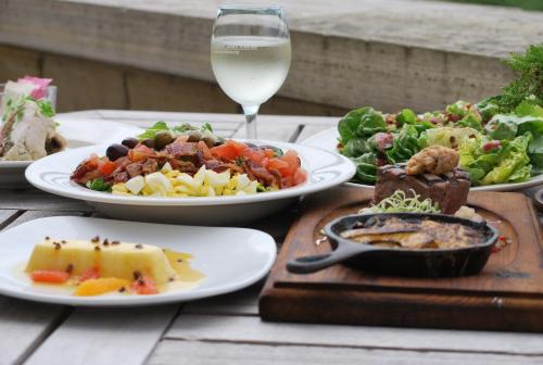 a table with plates of food and a glass of wine at Lied Lodge at Arbor Day Farm in Nebraska City