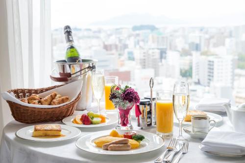 a table with plates of breakfast food and a window at ANA Crowne Plaza Hiroshima by IHG in Hiroshima