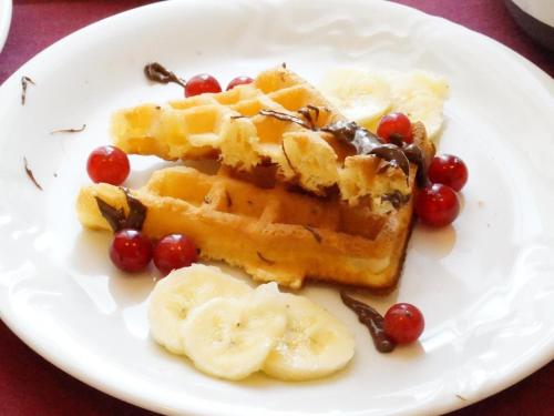 a white plate with waffles and fruit on it at Hotel U Brány in Uherský Brod