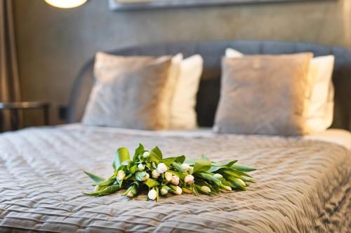 a bouquet of flowers sitting on top of a bed at Stay in Kaunas & Park House in Kaunas