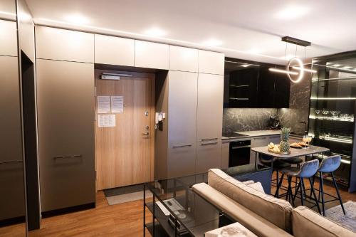 a kitchen and a living room with a couch and a table at Stay in Kaunas & Park House in Kaunas