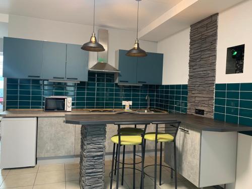 a kitchen with a counter with yellow bar stools at Апартаменти Маяк in Odesa