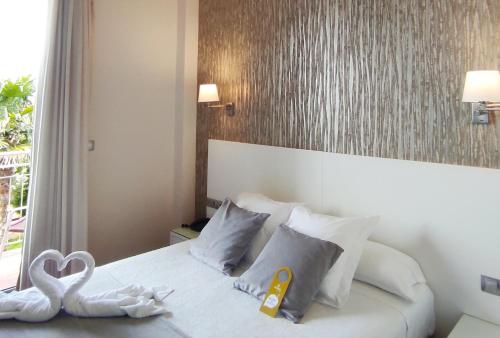 una habitación de hotel con una cama con un cisne en ella en Peregrina Hotel, en Sanxenxo