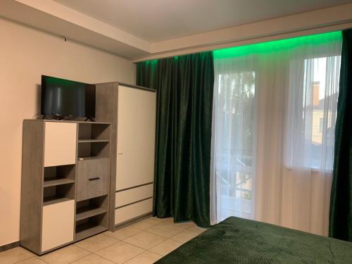 a bedroom with a bed and a television and green lights at Апартаменти Маяк in Odesa