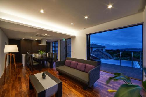 a living room with a couch and a large window at E-horizon Resort Premium 瀬底E in Sesoko
