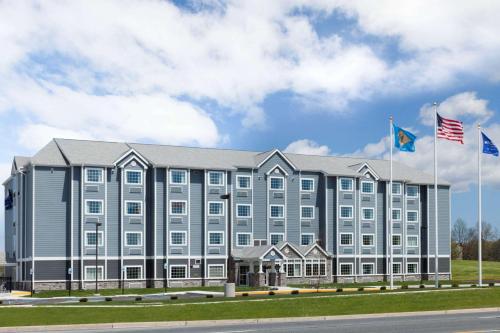 a large gray building with two american flags at Microtel Inn & Suites by Wyndham Georgetown Delaware Beaches in Georgetown