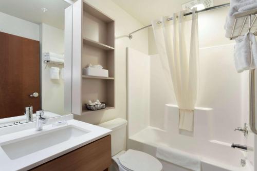 a white bathroom with a sink and a toilet at Microtel Inn & Suites by Wyndham Georgetown Delaware Beaches in Georgetown