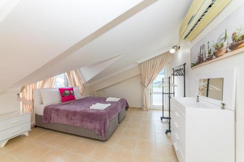 um quarto com uma cama com um cobertor roxo em Villa London Marmaris Daily Weekly Rentals em Marmaris