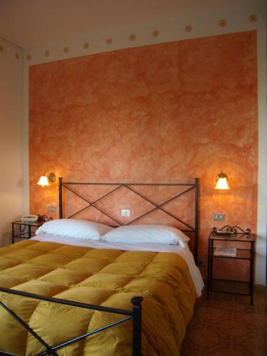 a bedroom with a large bed and two night stands at Hotel Sangallo B&B - panoramic position - Valley and vineyard view- family run in Montepulciano