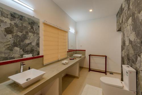 a bathroom with two sinks and a large mirror at Tara Watergate in Tissamaharama