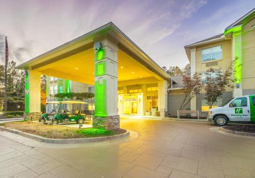 a building with a green sign in front of it at Holiday Inn Hotel and Suites Peachtree City by IHG in Peachtree City