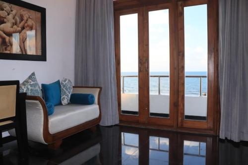 Il comprend un salon avec une chaise et un balcon. dans l'établissement Village Hotel Northern Point, à Point Pedro