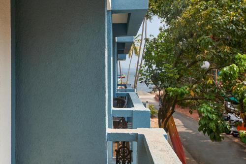 a blue building with a balcony with a view of the ocean at The Hawaii Comforts Panjim in Panaji