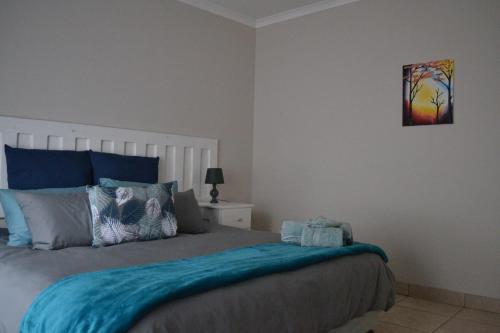 1 dormitorio con 1 cama con edredón azul en The Open Door Guest Suite, en Modimolle