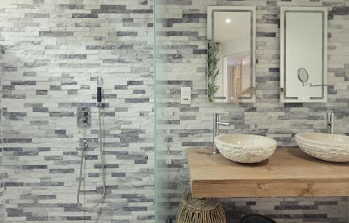 a bathroom with two sinks and a shower at AQUA Boutique Hotel in Glacis