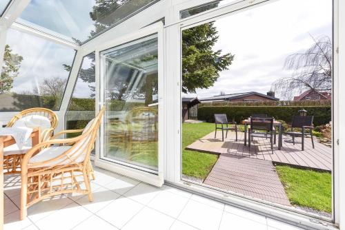 a screened in porch with a table and chairs at Ferienhaus Boje 13 in Neuharlingersiel