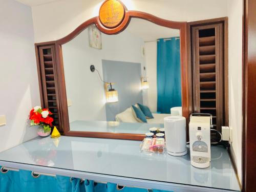 una camera d'albergo con bancone e specchio di Résidence de la baie - BLEU SOLEIL TARTANE a La Trinité