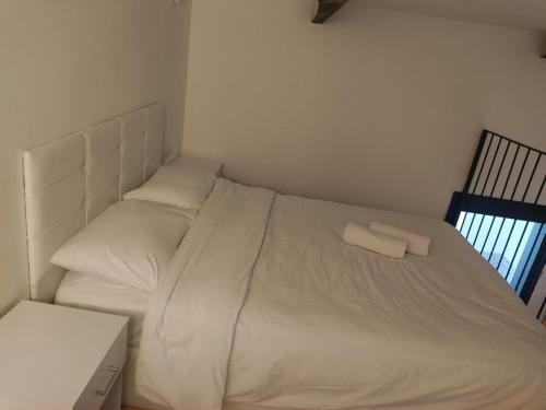 a white bed with two pillows on it in a bedroom at יחידת נופש בבית ורדי in Tiberias