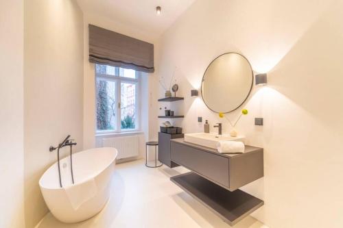 a bathroom with a tub and a large mirror at josef's home I Pink Flamingo I Deluxe Suite in Vienna