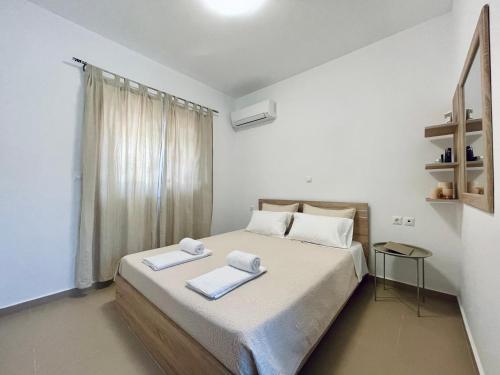 een slaapkamer met een bed met twee handdoeken erop bij Archangelos Garden House in Archangelos