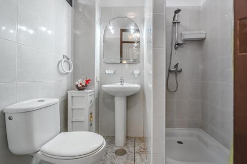 y baño con aseo, lavabo y ducha. en OLYMPIA APARTMENTS en Playa de las Américas