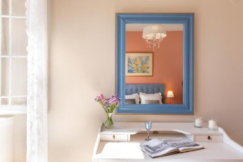 un espejo en una pared con una mesa con un espejo en Porta Spilea Boutique Apartments, en Corfú