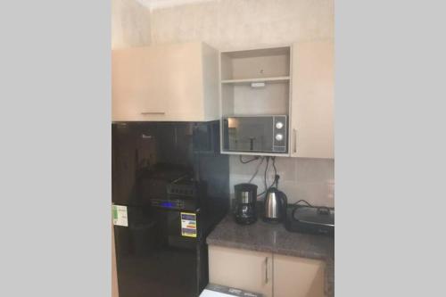 a kitchen with white cabinets and a black refrigerator at Executive 2 BedRoom Hotel Apmt Contactless check-in Premium Services and Quality at Madinaty in Madīnat ash Shurūq