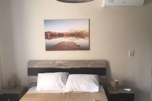 a bedroom with a bed with a picture on the wall at Executive 2 BedRoom Hotel Apmt Contactless check-in Premium Services and Quality at Madinaty in Madīnat ash Shurūq