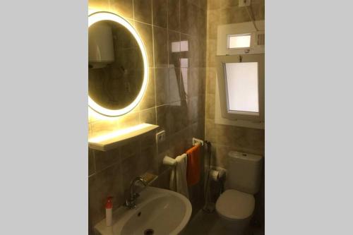 uma casa de banho com um lavatório, um espelho e um WC. em Executive 2 BedRoom Hotel Apmt Contactless check-in Premium Services and Quality at Madinaty em Madīnat ash Shurūq