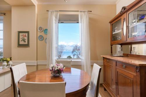 Un comedor con una mesa y una ventana. en Porta Spilea Boutique Apartments, en Corfú