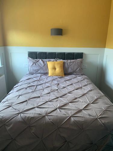 a large bed with two yellow pillows on it at The Woodleigh family hotel in Blackpool