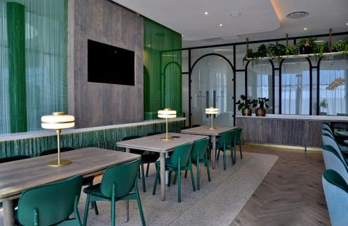 two tables and chairs in a restaurant with green walls at Courtyard Hotel Waterfall City in Midrand