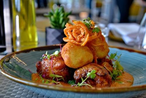 a blue plate with food on a table at Courtyard Hotel Waterfall City in Midrand