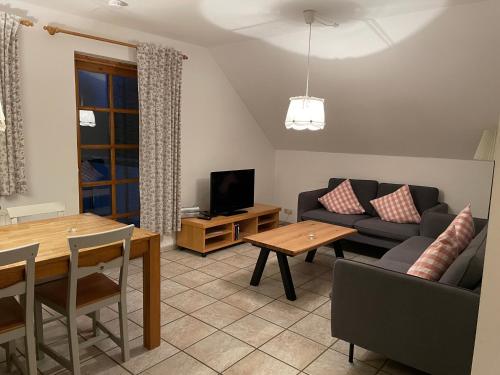 a living room with a couch and a table at Lindenhof Habernis in Steinberg