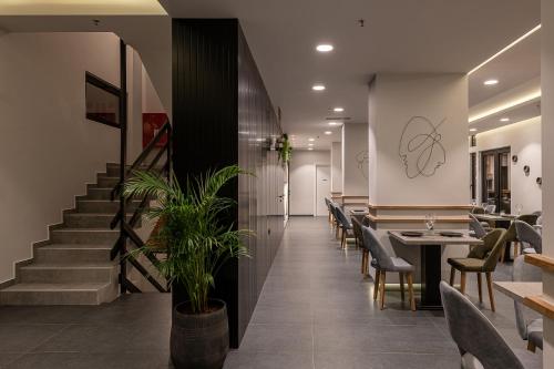 a restaurant with tables and chairs and a staircase at Morum City Hotel Chania in Chania Town